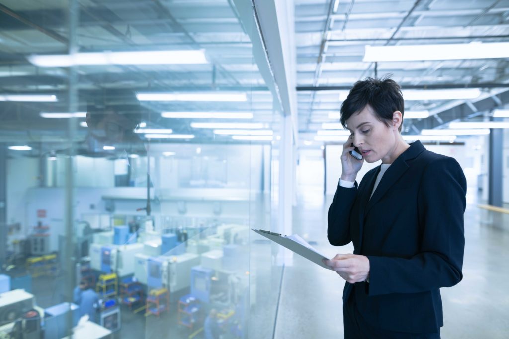 une femme d'affaires au téléphone dans une usine