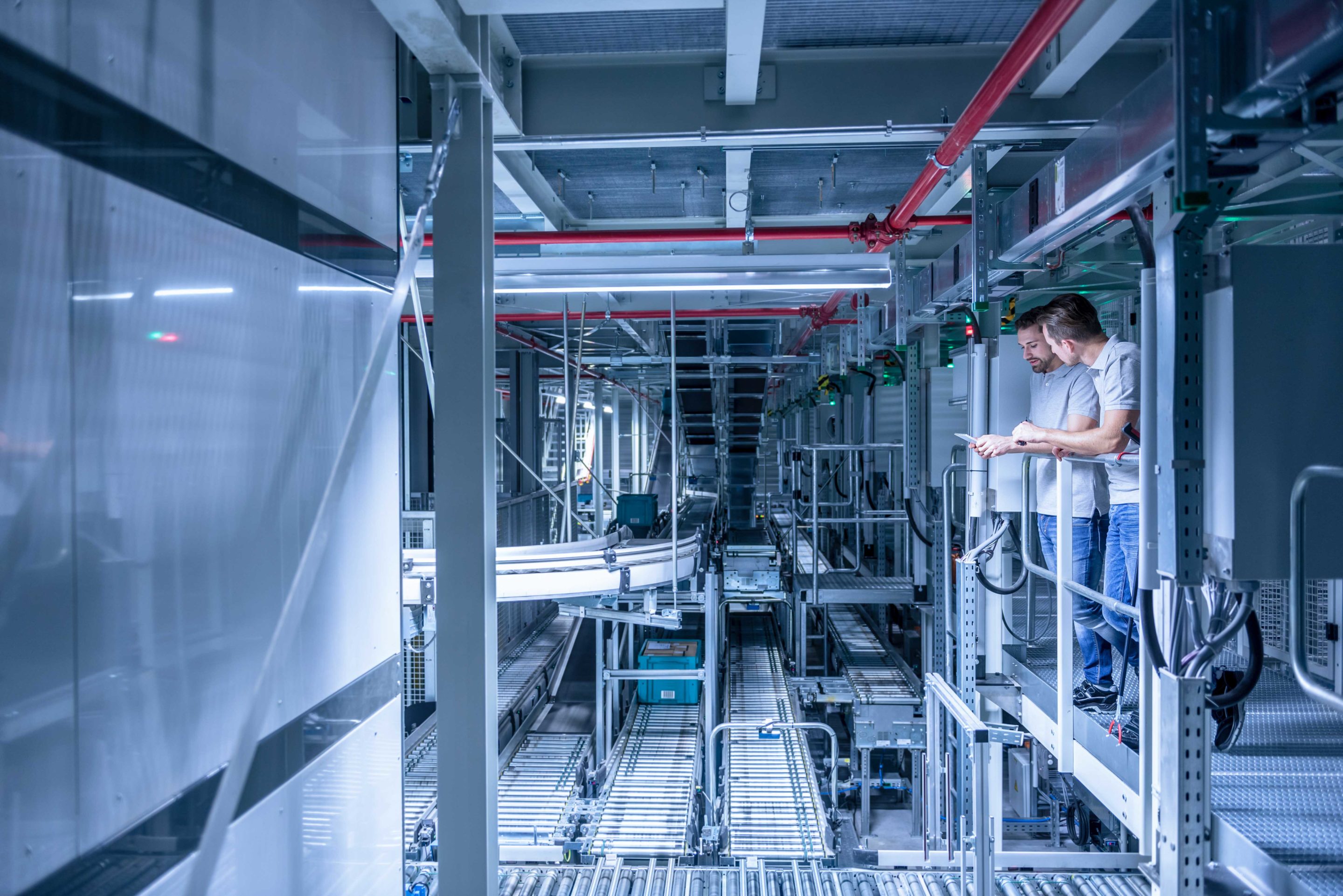 two factory workers inspect equipment