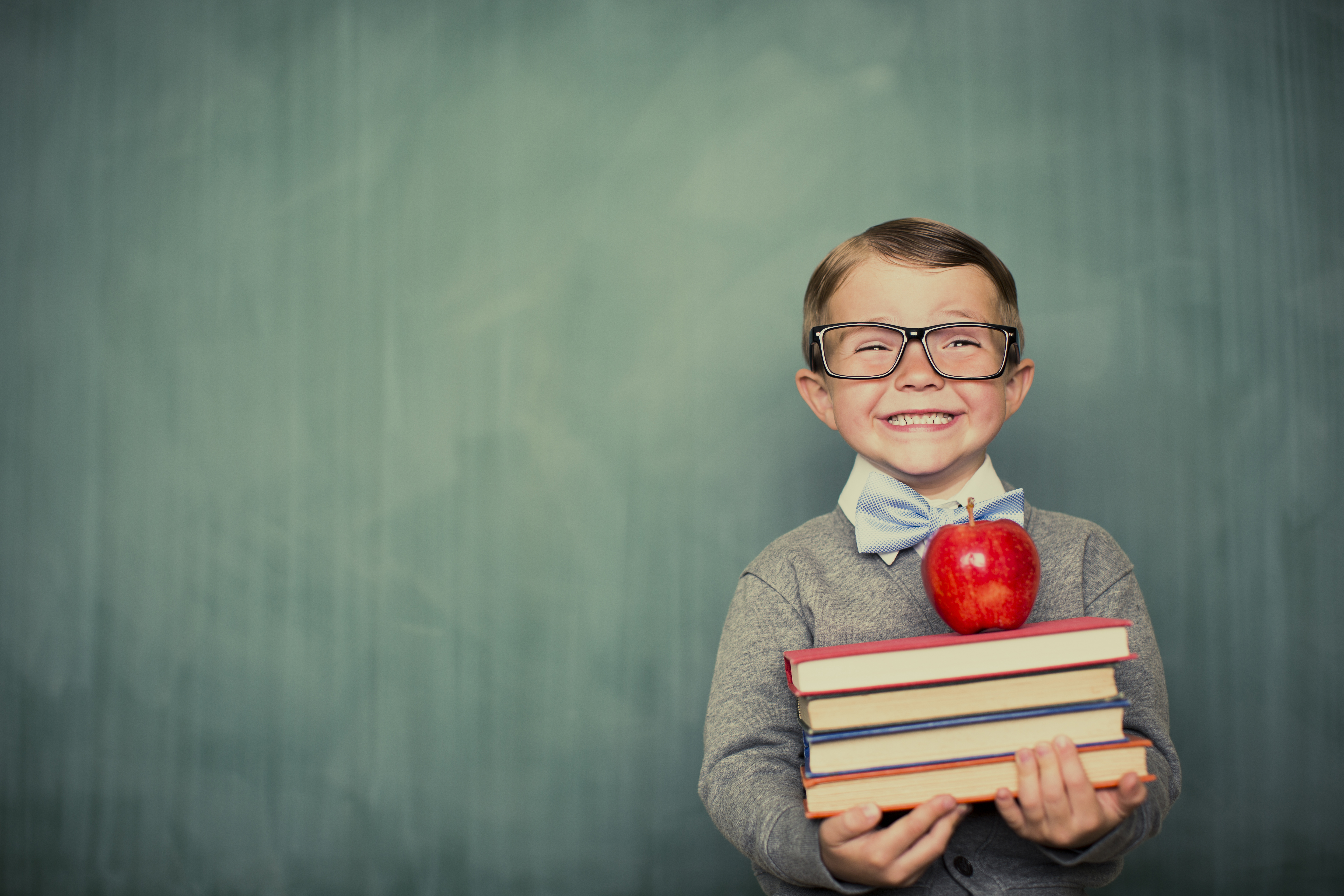 Boy holding textbooks and apple